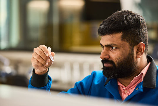 Man in a lab looking at a chemical product, Chem-Impex