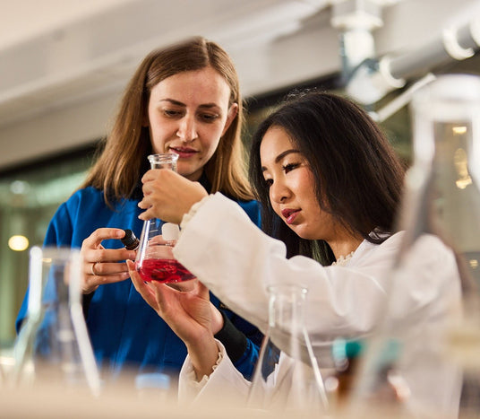 Two women in a lab looking at chemicals Chem-Impex